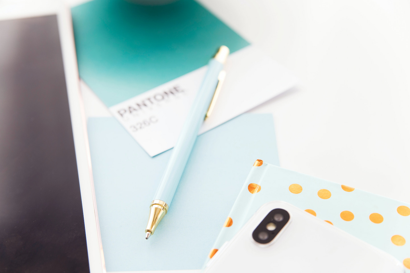 Un stylo, un carnet et un pantone dans les teintes turquoise