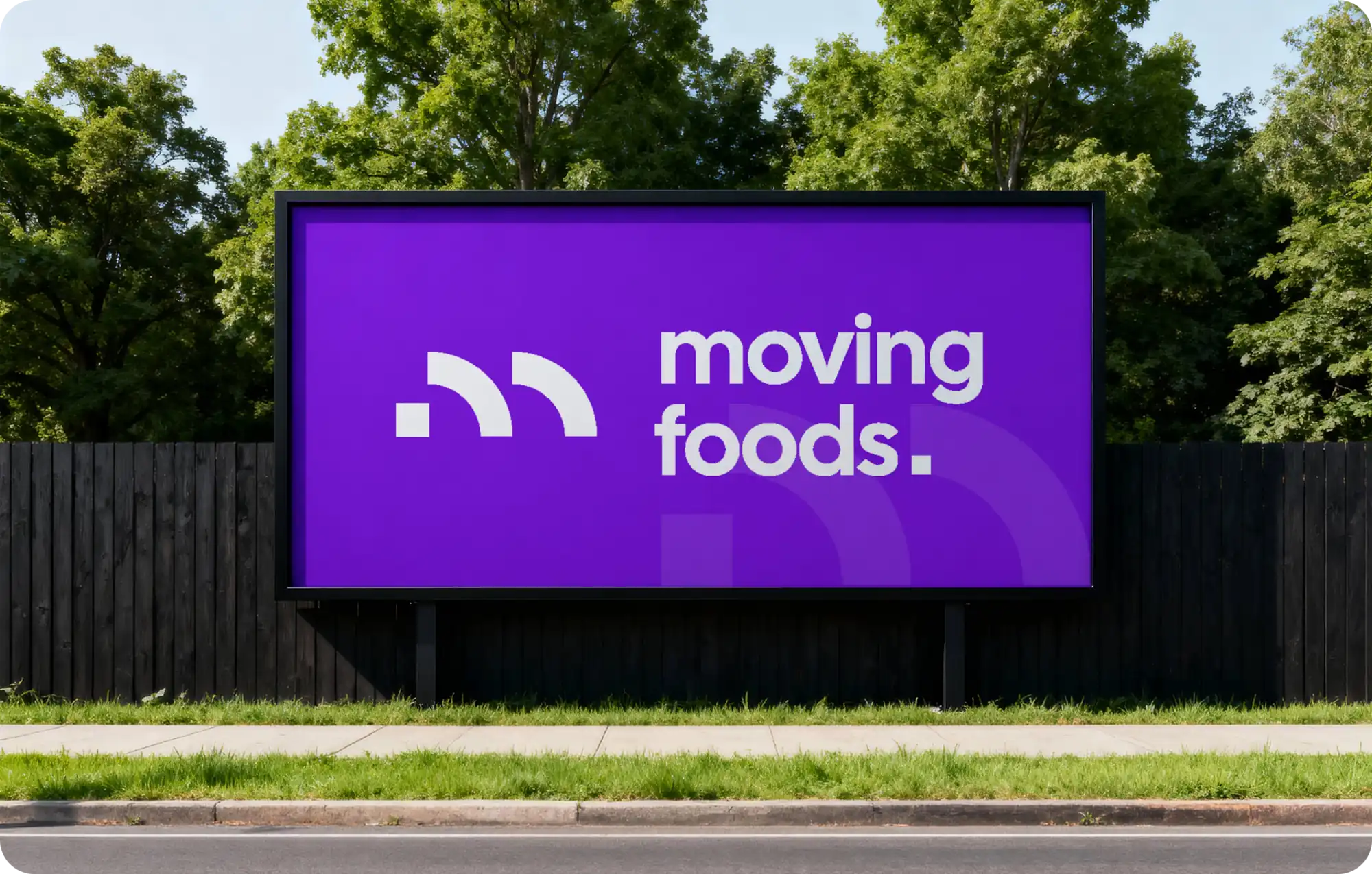 Panneau 4x3 en bord de route affichant le logo Moving Foods en blanc sur fond violet, entouré d'arbres